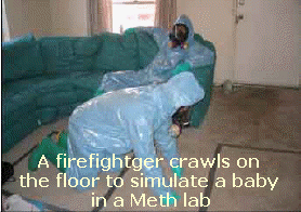 Firefighter in HazMat suit crawls on floor